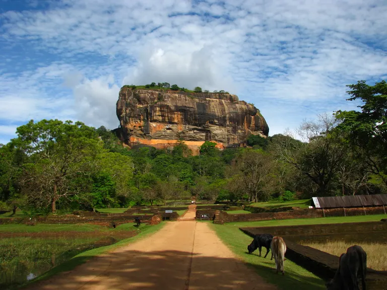 The sunlit face of Sigiriya rock above its gardens